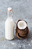 Coconut milk in a bottle with a fresh coconut