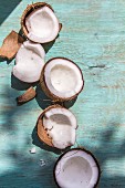 Broken coconuts on a wooden board in sunlight