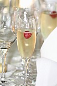 Raspberries in glasses of champagne on a table at a wedding