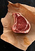 A raw prime rib steak on a piece of paper