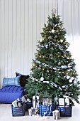 Geschmückter Weihnachtsbaum mit Geschenken in blauen Körben