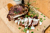Grilled knuckle of lamb with yoghurt sauce on a chopping board