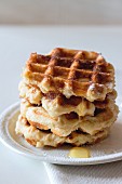 A stack of Belgian waffles with syrup