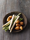 White and green asparagus with potatoes in a wooden bowl