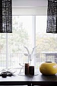 Black pendant lights over dining table in front of balcony window
