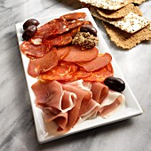 Spanish charcuterie platter with Serrano ham and black olives