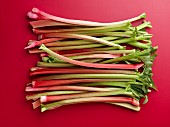 Rhubarb stalks on a red surface