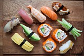 Various types of sushi on a chopping board (seen from above)