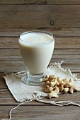 A glass of cashew nut milk with cashew nuts
