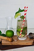 A mojito with limes, mint and straws