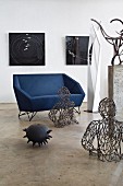 Angular designer sofa surrounded by modern artworks in interior with polished concrete floor