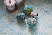 Furniture knobs with crocheted covers on surface with vintage pattern