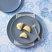 A place setting with blue plates and mushroom filled pastry parcels