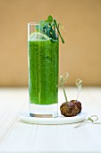 A cucumber and mint mojito in a glass with a mini lamb meatball