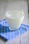 A glass of buttermilk on a spotted napkin