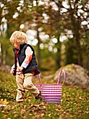 Little boy walking through an autumn woodland clearing