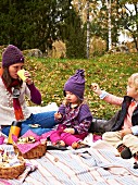 Mother and children enjoying an autumn woodland picnic
