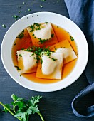 Gluten-free Swabian ravioli filled with vegetables and sausage meat swimming in meat broth