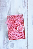 Strips of pink silk paper in a box as decoration