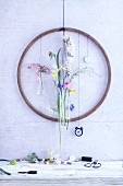 An old wooden hula hoop on a wall decorated with spring flowers