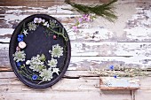A tray decorated with summer flowers on a wooden surface