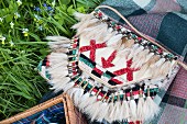 An embroidered handbag with a Native American pattern and fur tassels
