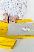 A cushion cover being cut from yellow raincoat material