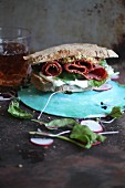 Wholemeal sandwich with salami, lettuce, remoulade and mustard