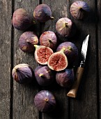 Figs on a wooden table, one slice, with a knife
