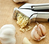 A garlic crusher and garlic