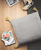 A homemade floor cushion knitted from grey woollen yarn