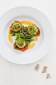 Scallops with a herb crust on a green asparagus salad with a tomato dressing