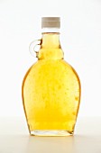 Ingwersirup als Zuckerersatz in Glasflasche vor weißem Hintergrund