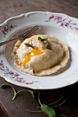 Ravioli with a mushroom and ricotta filling and egg yolk served with sage butter