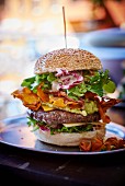 A burger with guacamole and sweet potato chips