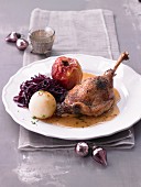Goose leg with a baked apple, red cabbage and a potato dumpling