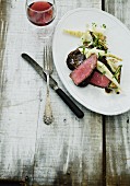Rare venison steak with oven-roasted vegetables
