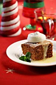 A slice of spiced cake with vanilla sauce and cream for Christmas