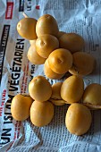 Fresh yellow dates from a market on a piece of newspaper