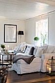 White sofa with many scatter cushions in cosy living room
