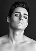 An androgynous young man wearing eye make up (black and white shot)