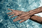 Frauenhände unter Wasser im Pool