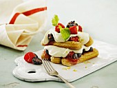 A layered dessert with sponge fingers, berries and mascarpone cream