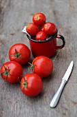 Tomatoes with a knife on a wooden surface