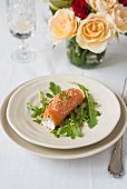A smoked salmon roll with the yoghurt, sesame seeds and rocket