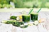 Spinach, cucumber, ginger and apple smoothies on a wooden table
