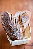 Two loaves of French bread in a wooden basket