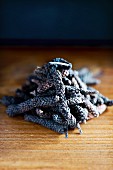A close-up on long Java pepper on a rustic wooden table