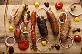 A wooden platter with various sausages and spices