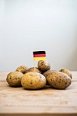 A paper German flag in the middle of a pile of potatoes
